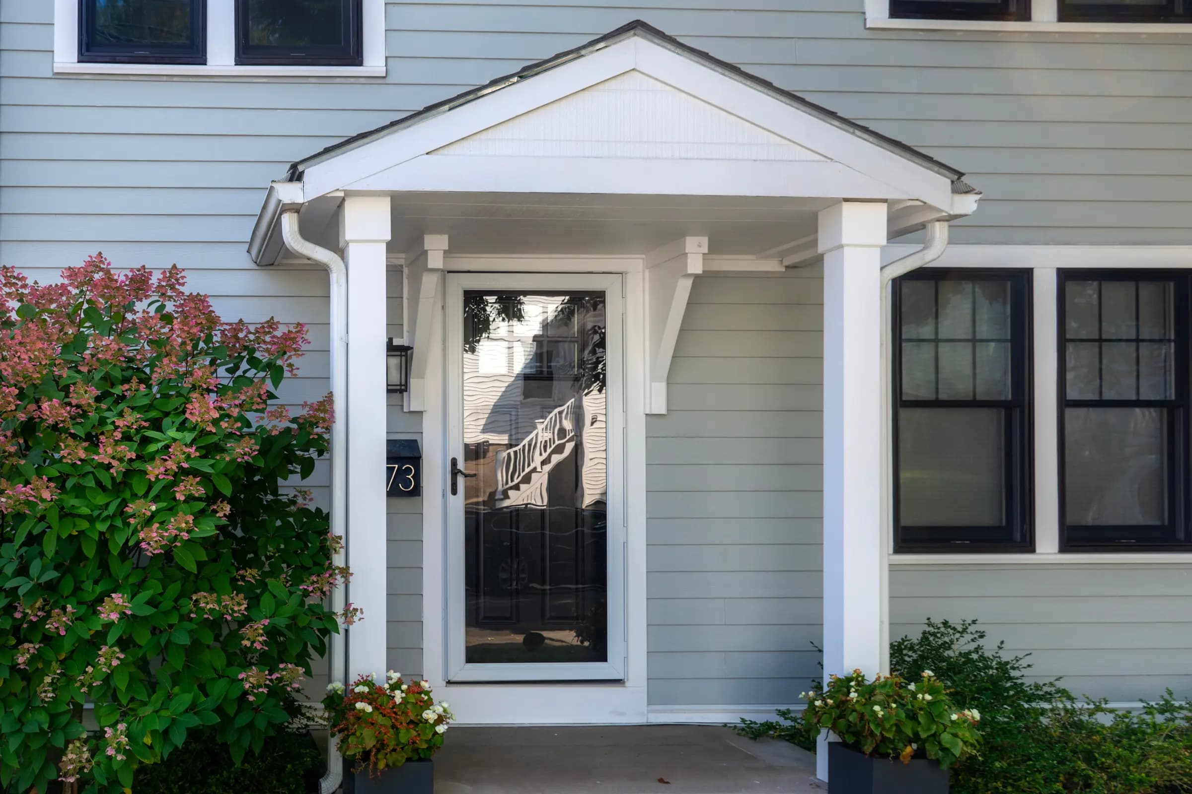 Full-view storm door over an entry door on a sided home